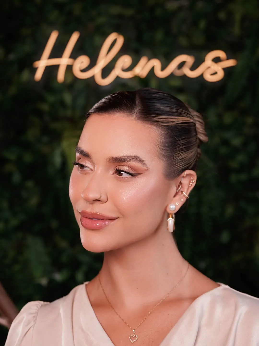 Julia Helenas em frente ao neon Helenas